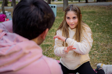 Woman gesturing with hands while playing mimic with her friend