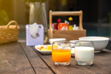 Fototapeta na wymiar Glass of orange juice and milk on breakfast table.