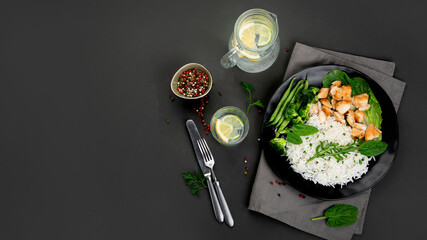 Delicious healthy homemade chicken and rice diner with fresh vegetables on gray background.