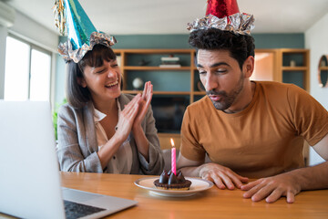 Couple celebrating birthday on a video call at home.
