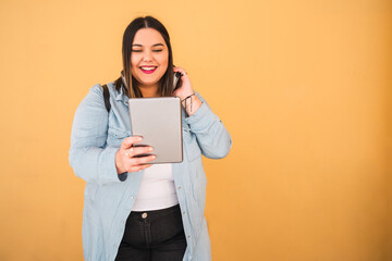 Woman listening music with headphones and tablet.