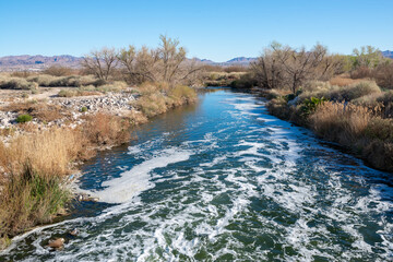 Las Vegas Wash flowing swiftly towards Lake Mead below a weir at Clark County Wetland Park