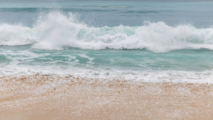Seascape background. Sandy beach, milky foam waves, blue ocean. Scenic waterscape. Nature and environment concept. Daylight. Copy space. Dreamland beach, Bali