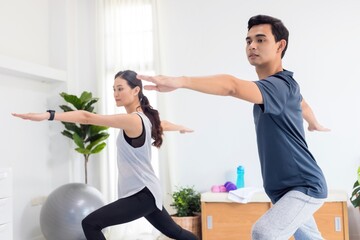 Asian young couple exercise together at home background.Concept of Exercise during the quarantine at home for preventing coronavirus and covid-19 infection.