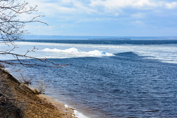 Natural ice blocks breaking up against shore during spring weather. Arctic, winter, spring landscape. Ice drift.