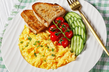 scrambled eggs with veggies and bread on a plate