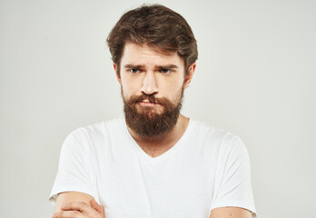 Obraz premium Bearded man in white T-shirt puzzled look sad face cropped look