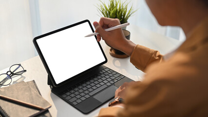 Close up view of young man graphic designer holding stylus pen pointing on screen of digital tablet...