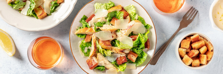Caesar salad panorama with wine and croutons, the classic recipe with grilled chicken and Parmesan
