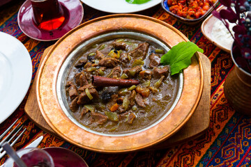 Turkish lamb meat saute mutancana with prunes and rice in traditional ceramic plate