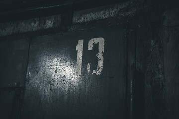 the number "13" written with paint on a rusty surface. failure concept. unlucky number.