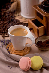 cup of coffee and coffee beans in a sack on dark background, top view