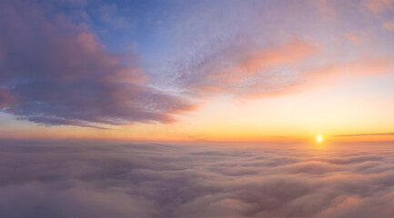 Fototapeta na wymiar view from an airplane on a beautiful saturated sunrise above the clouds