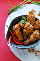 Top view of Spicy Chicken Wings in Bowl on Red Background