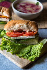 Close up of sandwich with vegetables and cheese with lettuce leaves as condiments