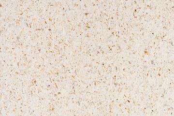 Texture of beige paper with splashes of wood shavings close up. Abstract eco background of recycled...