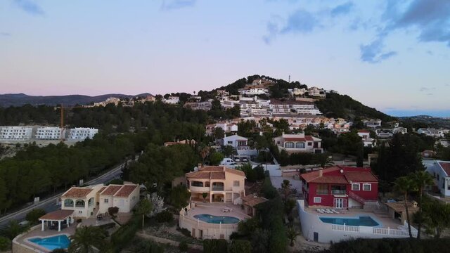 Drone footage of houses with swimming pools and relaxed community lifestyle from Calpe, Spain on a warm evening