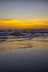 Yellow sunset on the beach. Seascape for background. Colorful sky. Beautiful water reflection. Sunlight on horizon line. Nature and environment concept. Copy space. Sunset in Bali.