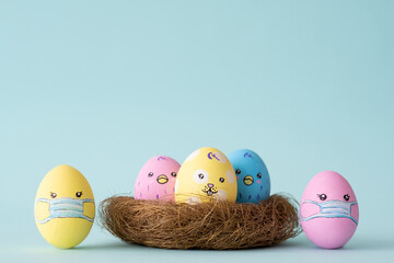 Covid-19 banner. Pandemic Easter. Home celebration. Painted egg in protective face mask design happy family with cute bunny chicken face in nest isolated on blue empty space background.