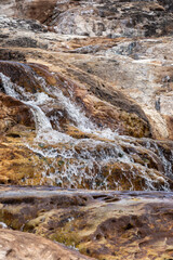 Fototapeta na wymiar Water flowing down a small waterfall in an almost dried out river during the dry seaon close to Botumirim in Minas Gerais, Brazil,