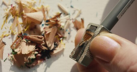 Sharpening pencil sharpener in female hands or fingers macro close up