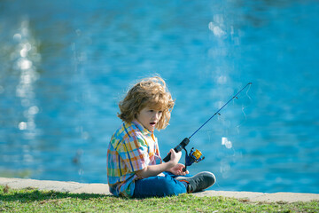 Happy child fishing on the lake. Boy with spinner at river. Fishing concept.