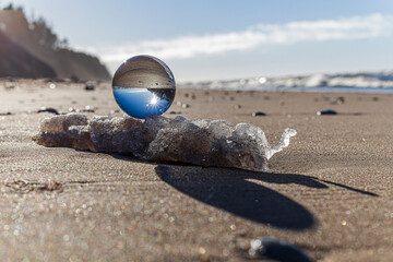 Glass ball stands at sea in the sand of Jurmala