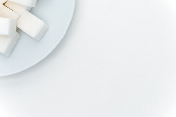 granulated sugar cubes on a plate sweets light background