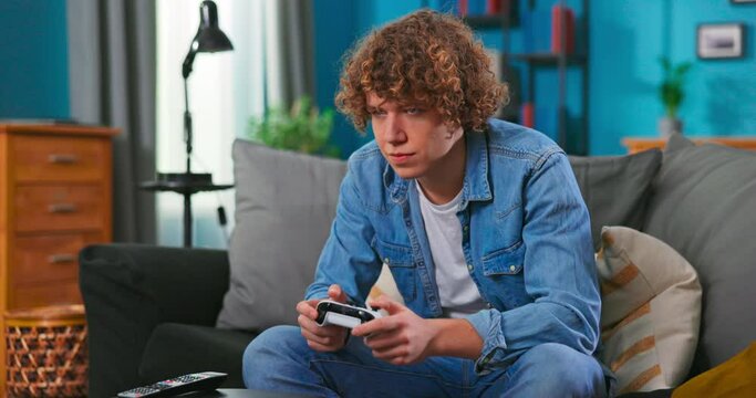 Happy man playing video games in apartment - Hilarious teenager boy having fun with new trend console technology. People entertainment concept