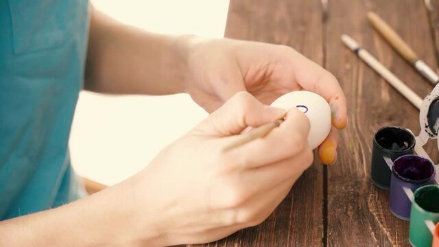 Woman hand painting on easter egg medical mask