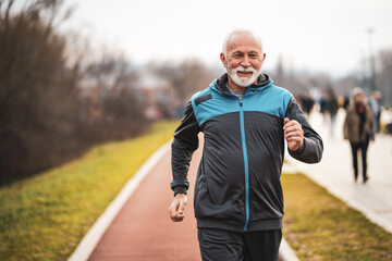 Fototapeta premium Active senior man is jogging. Healthy retirement lifestyle.