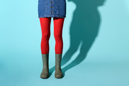 Young woman in green rubber boots and red pantyhose or collant