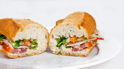Famous Vietnamese food is banh mi thit, popular street food from bread stuffed with raw material: pork, ham, pate, egg and fresh herbs as scallions, coriander, carrot, cucumber, chilli.