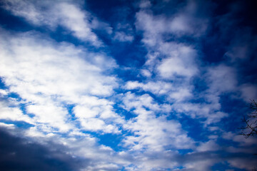 Naklejka na ściany i meble Spring March sky with white fluffy clouds Ukraine