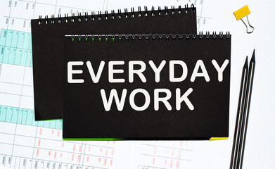 text EVERYDAY WORK Written words on paper notebook . workplace. Business concept.