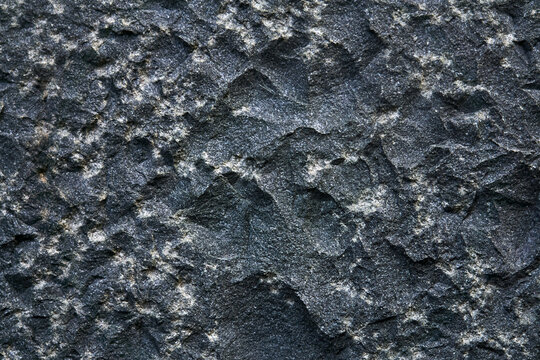 background, texture - the surface of a roughly hewn granite block