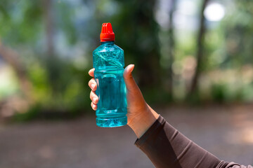 Clear blue green water bottle, the lid is red with a hole in the center for portability, natural...