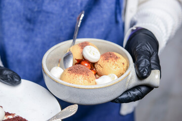 Caramel ice cream served by waiter in restaurant or cafe. Cold dessert, vanilla ice cream with sweet caramel.