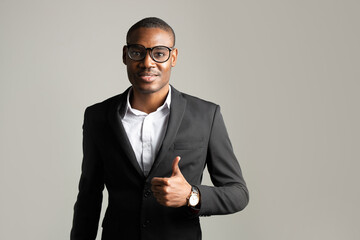 portrait of young african man in suit wearing glasses with hand gesture 