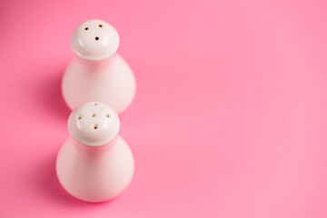 Salt and Pepper shaker isolated on pastel pink background. Copy space banner