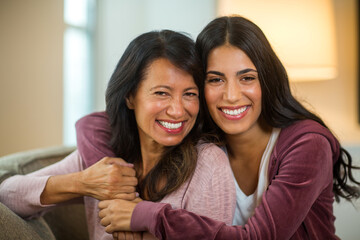 Mother and her adult daughter hugging and laughing