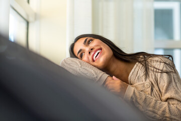 Young woman sitting on the sofa looking out the window