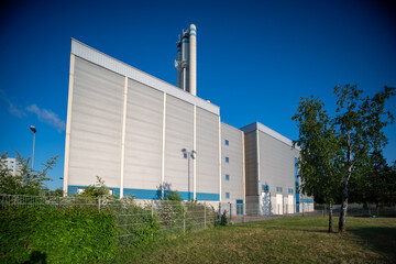 Industrial plant building with pipes against the blue sky