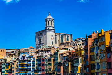 Girona, Spain - July 28, 2019: Colorful houses with balconies at the Jewish quarter of Girona, Catalonia, Spain, with Saint Mary cathedral overlooking the area