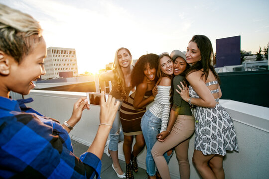 A group of young women partying on a city rooftop at dusk