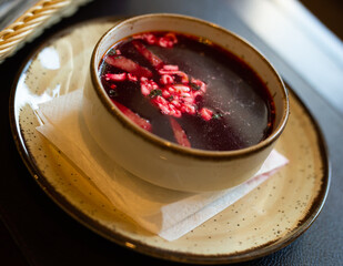 Appetizing hot borscht with sour cream in bowl