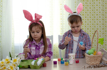 Happy easter! funny funny children with ears hare getting ready for holiday. Kids celebrating Easter. Home decoration
