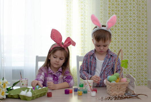 Happy easter! funny funny children with ears hare getting ready for holiday. Kids celebrating Easter. Home decoration