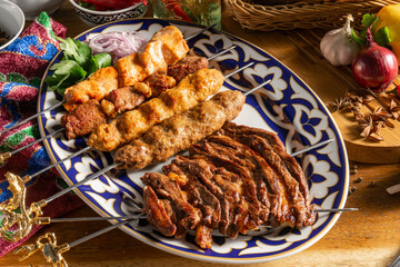 Lamb kebab and chicken lcula-kebab on a plate with Uzbek ornament