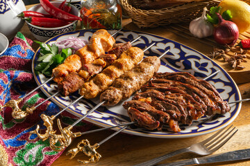 Lamb kebab and chicken lcula-kebab on a plate with Uzbek ornament